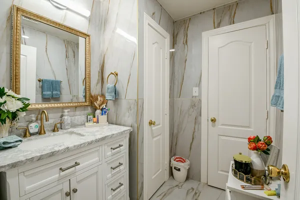 a bathroom with a granite countertop sink a vanity and a mirror