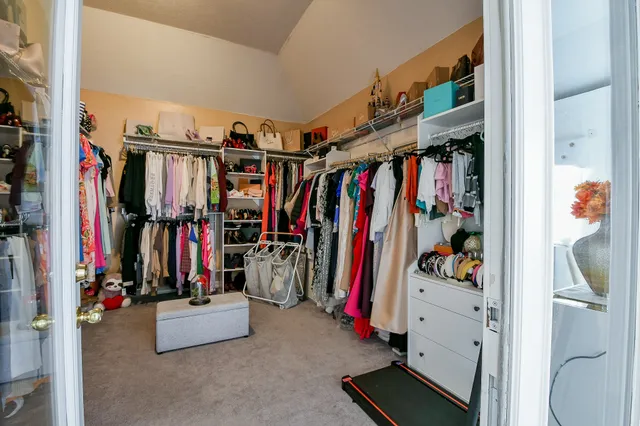 a view of walk in closet with clothes