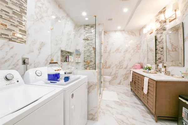 a bathroom with a sink double vanity mirror and a bathtub