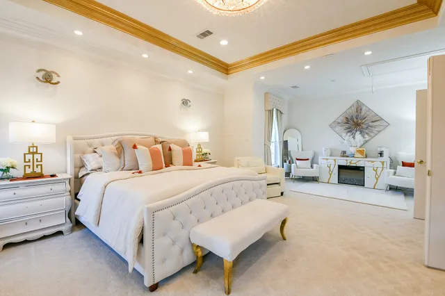 a spacious bedroom with a bed a table and painting on the wall