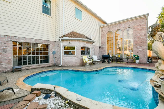 a view of a house with swimming pool and sitting area