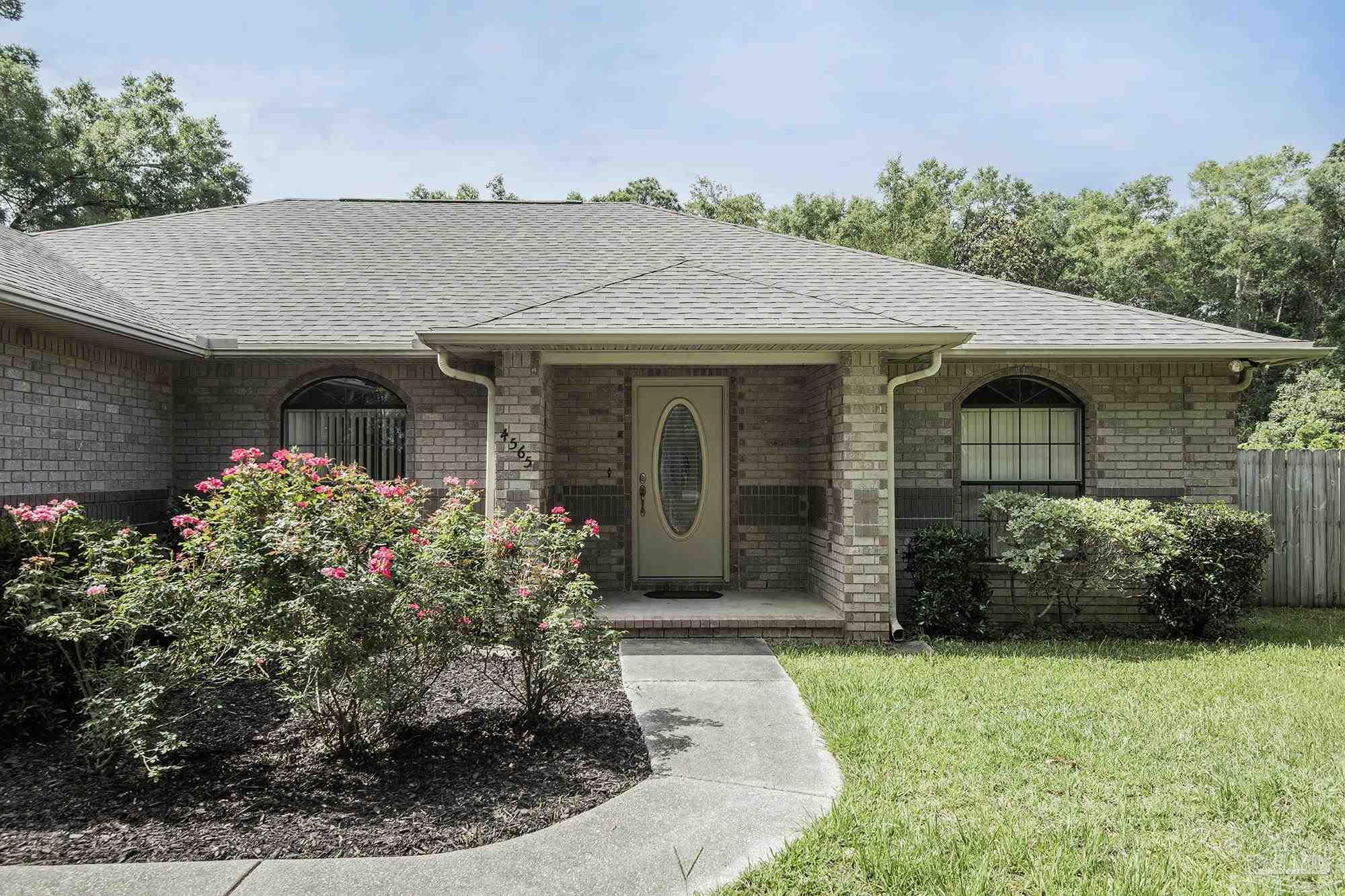 4565 South Spencer Field Road Pace, FL 32571 - Photo 1 of 49 a front view of a house with garden