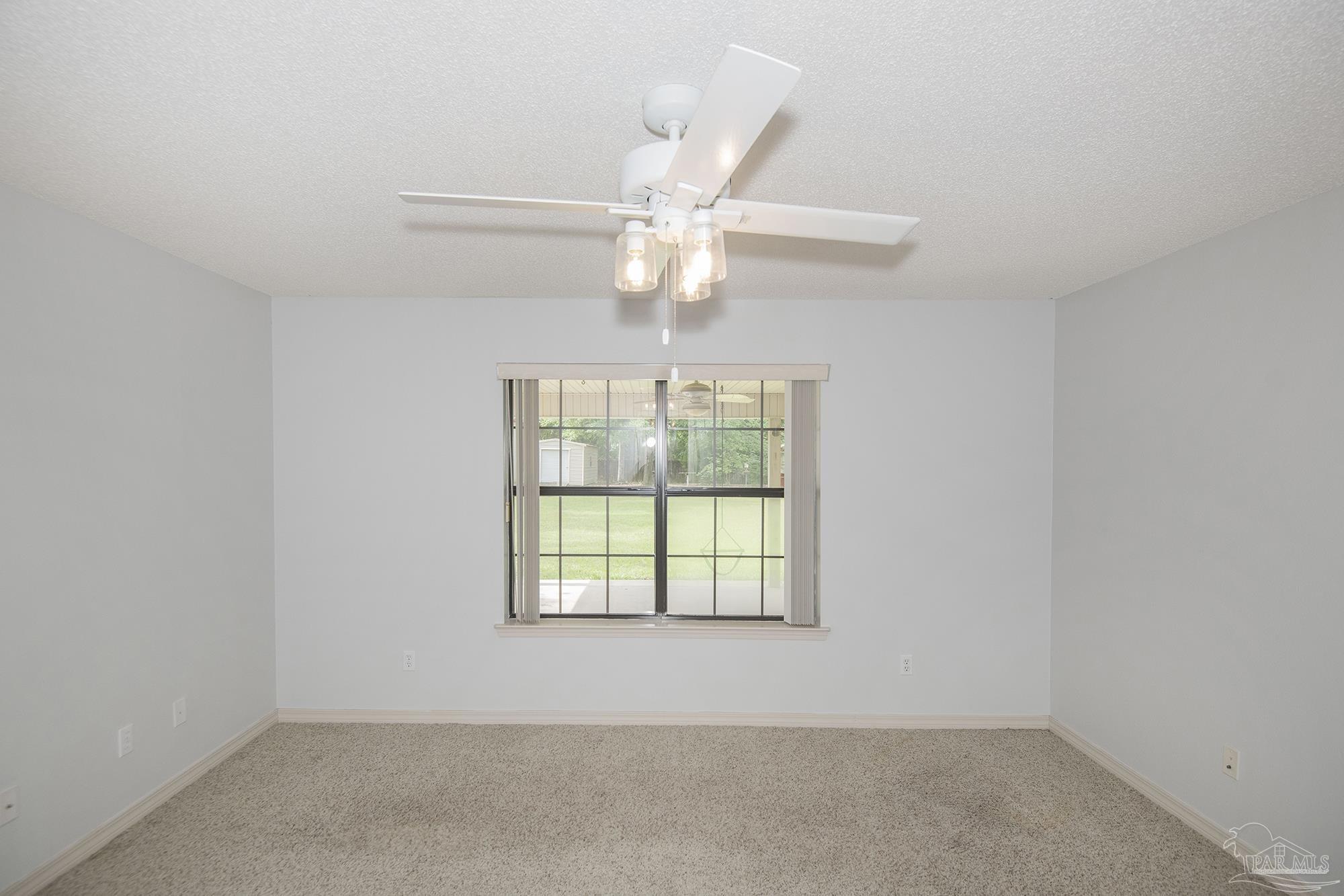 4565 South Spencer Field Road Pace, FL 32571 - Photo 14 of 49 an empty room with a window and a fan