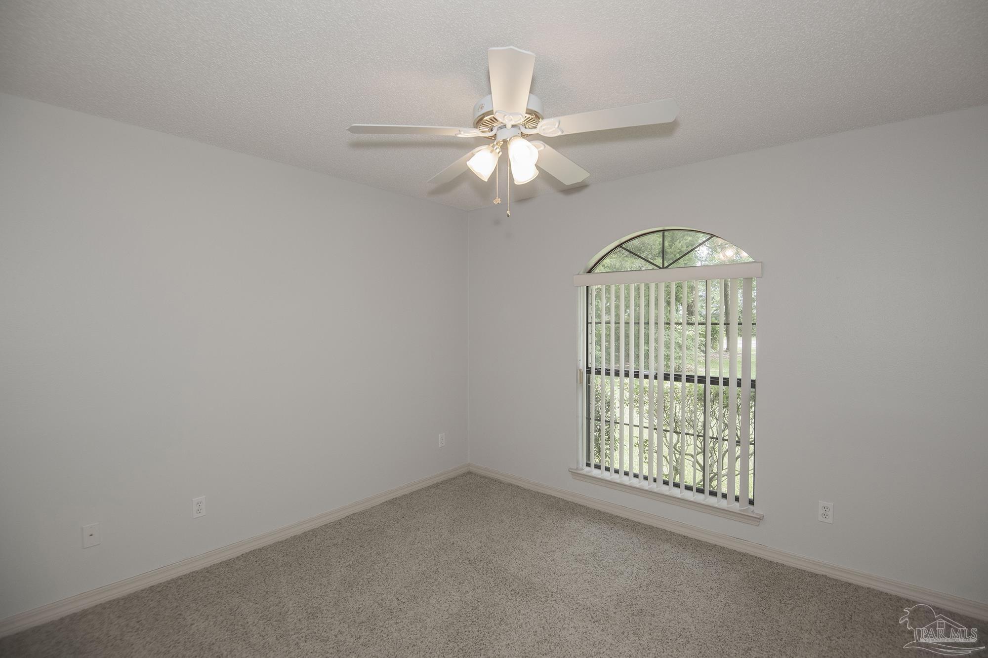 4565 South Spencer Field Road Pace, FL 32571 - Photo 15 of 49 an empty room with chandelier fan and windows
