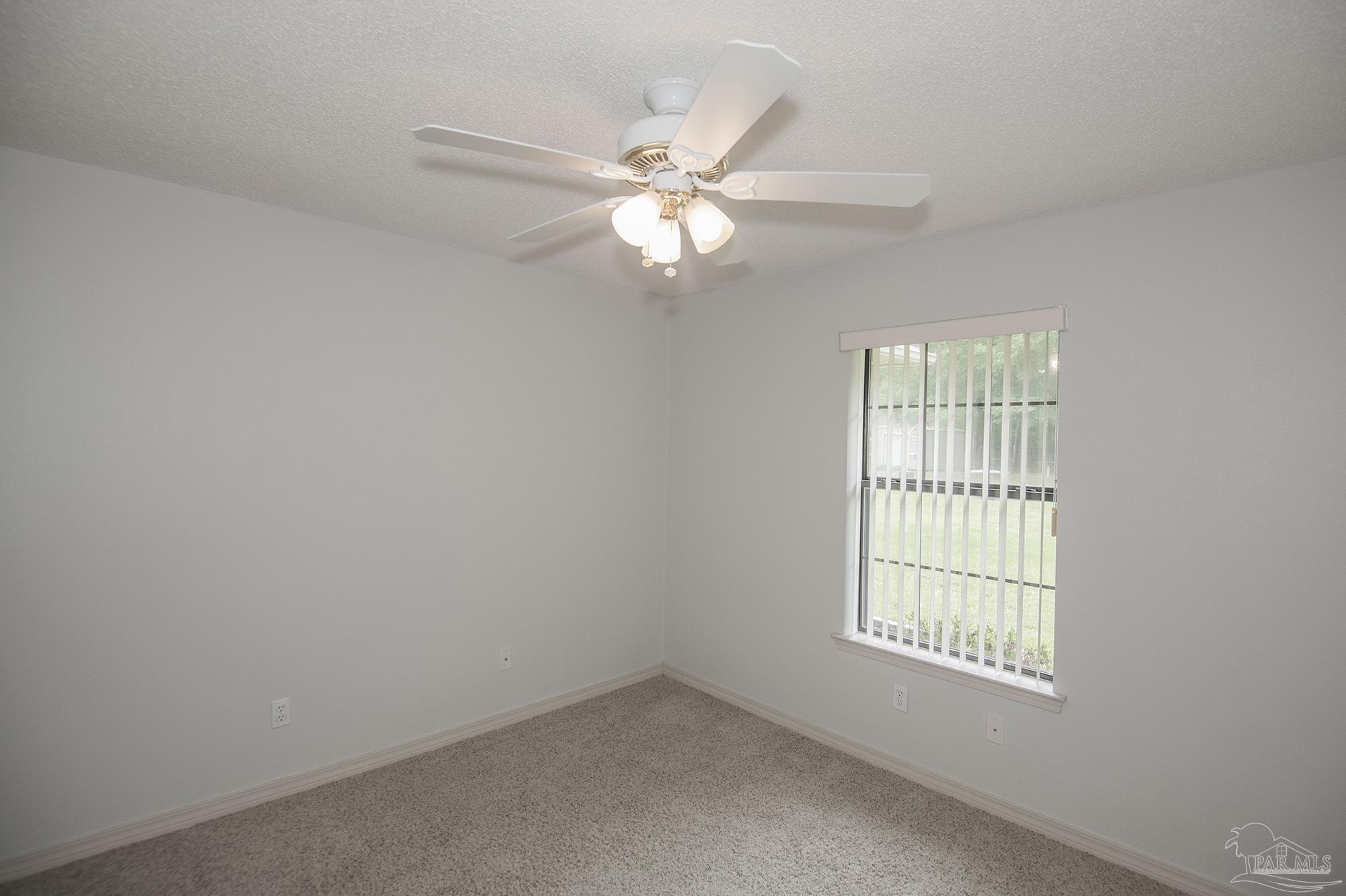 4565 South Spencer Field Road Pace, FL 32571 - Photo 16 of 49 an empty room with windows and fan