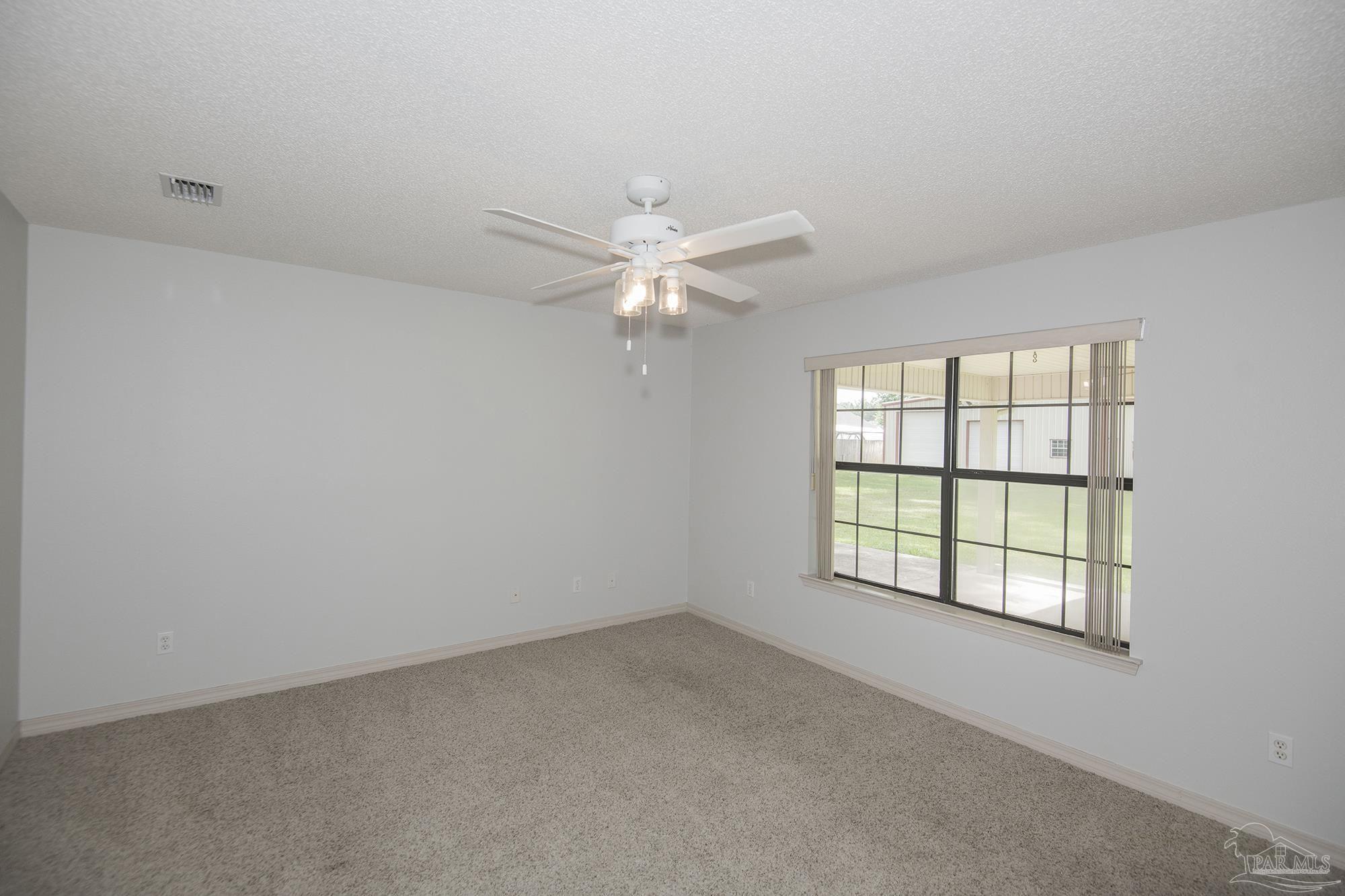 4565 South Spencer Field Road Pace, FL 32571 - Photo 21 of 49 an empty room with windows and ceiling fan