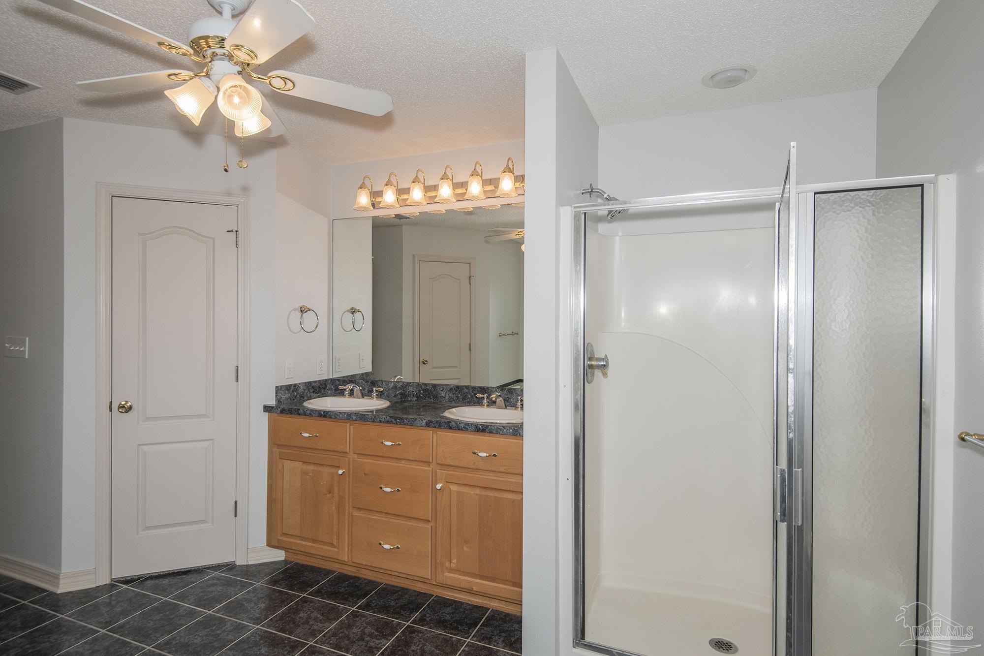 4565 South Spencer Field Road Pace, FL 32571 - Photo 24 of 49 a bathroom with a granite countertop sink a mirror and a shower