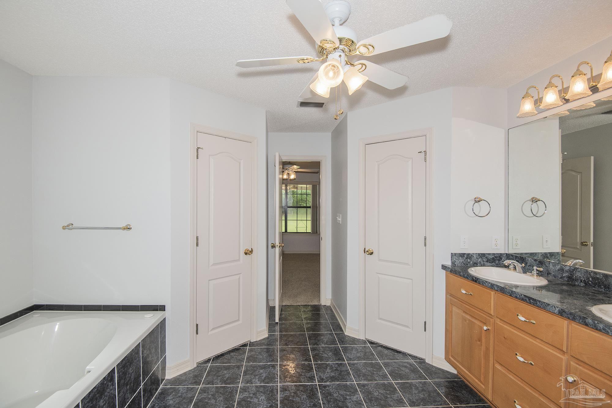 4565 South Spencer Field Road Pace, FL 32571 - Photo 27 of 49 a spacious bathroom with a granite countertop sink a mirror and a shower
