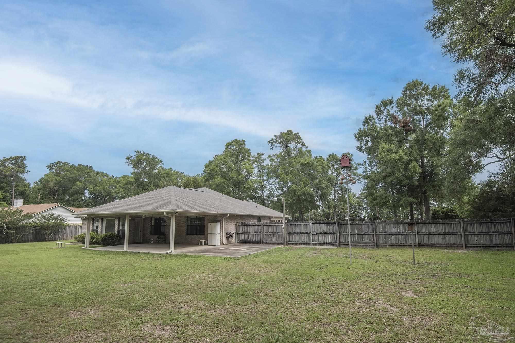 4565 South Spencer Field Road Pace, FL 32571 - Photo 35 of 49 a yellow and red house with a garden