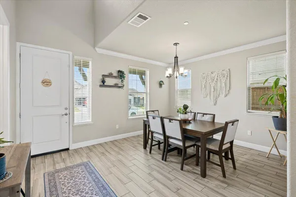 a view of a dining room with furniture and a chandelier