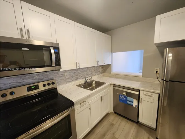 a kitchen with a stove microwave and sink