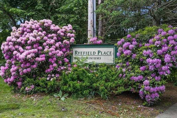 a sign that is sitting in front of flowers