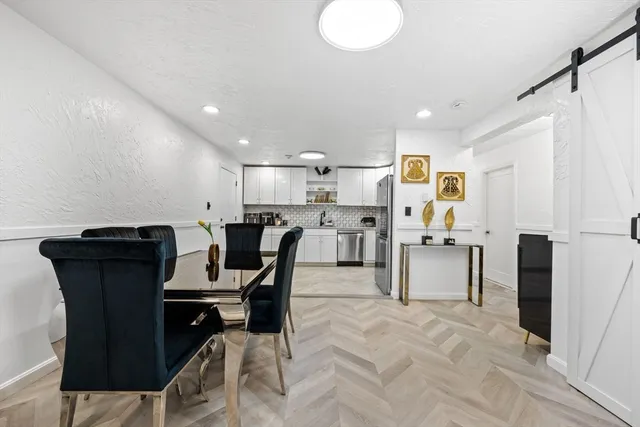 a view of kitchen with dining area and chandelier
