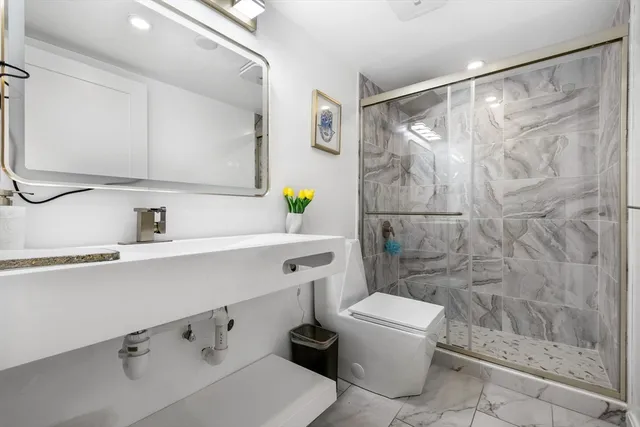 a bathroom with a sink a toilet and shower