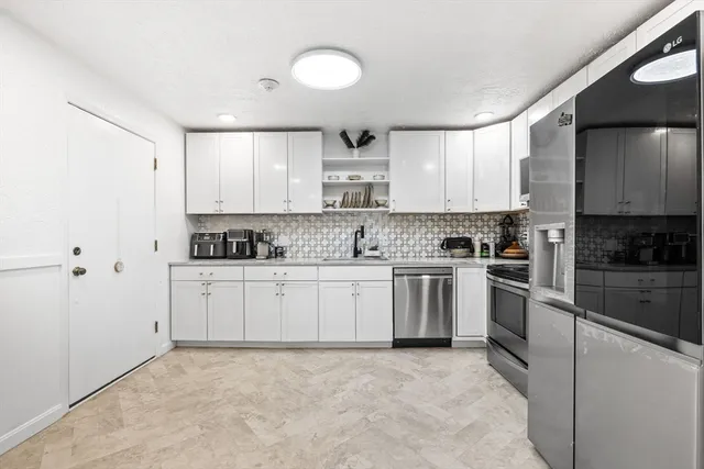 a kitchen with stainless steel appliances granite countertop a stove a sink and a refrigerator