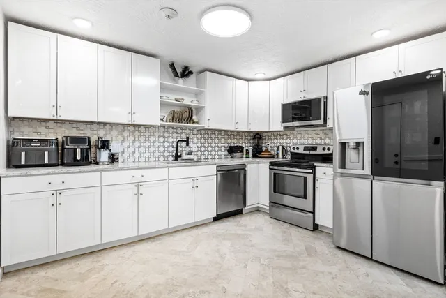 a kitchen with white cabinets stainless steel appliances and sink