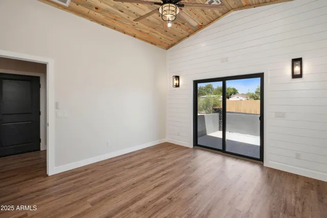 an empty room with wooden floor and door