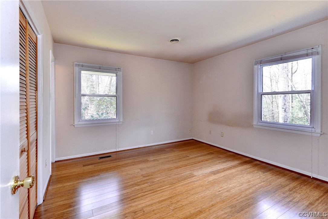 130 Cooley Road Williamsburg, VA 23188 - Photo 12 of 30 an empty room with wooden floor and windows
