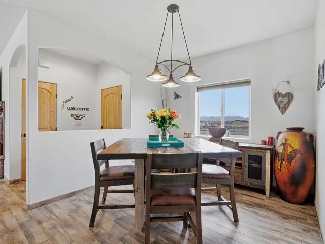 a view of a dining room and livingroom with furniture wooden floor a chandelier