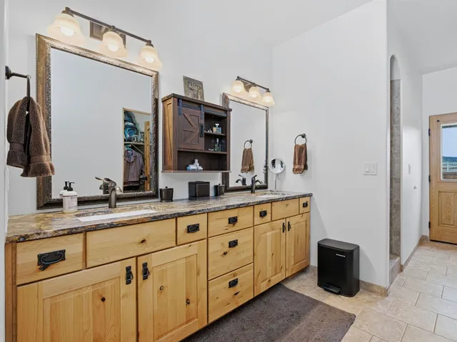 a spacious bathroom with double sink and a mirror