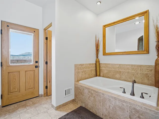 a bathroom with a tub sink and mirror