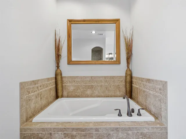 a bathroom with a tub sink and mirror