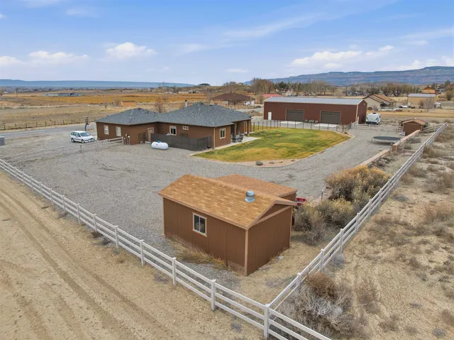 an aerial view of residential houses with outdoor space and ocean