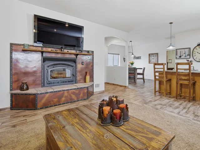 a living room with furniture a flat screen tv and kitchen view