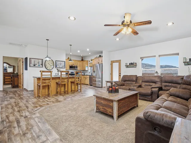 a living room with furniture kitchen view and a chandelier