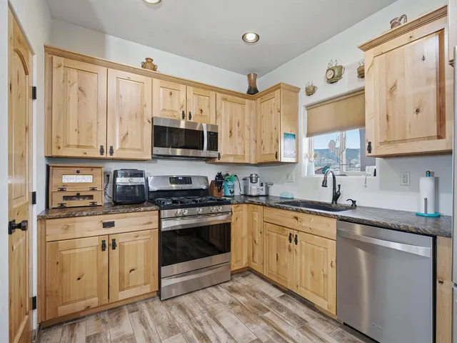 a kitchen with stainless steel appliances granite countertop a stove a sink and white cabinets