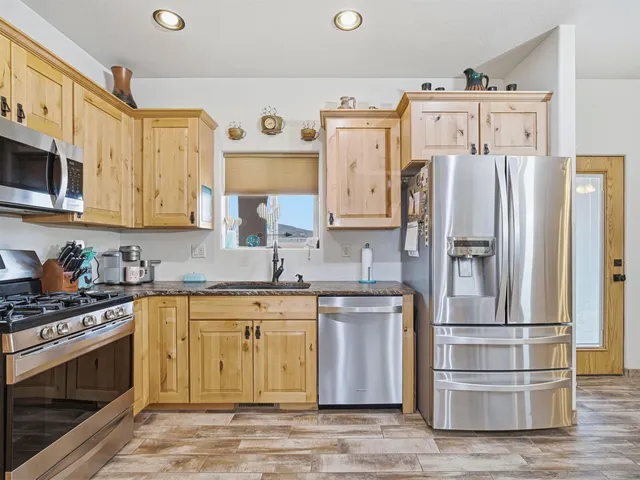 a kitchen with stainless steel appliances granite countertop a refrigerator and a stove top oven
