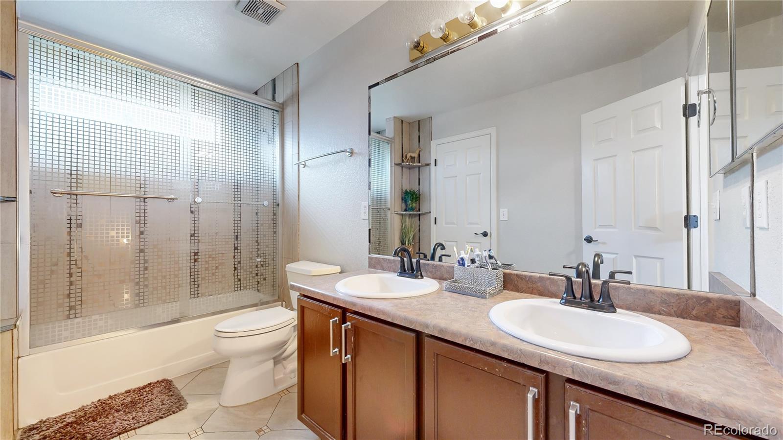 1173 Fall River Circle Longmont, CO 80504 - Photo 15 of 47 a bathroom with a granite countertop sink a toilet a mirror and shower