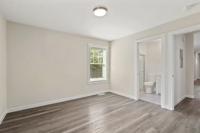 an empty room with wooden floor and a window