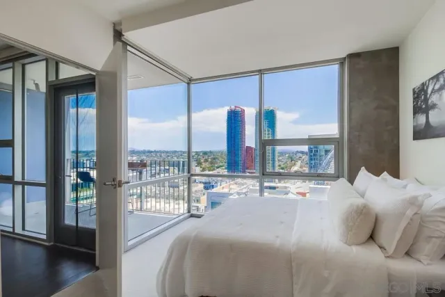 a bedroom with a large window and a bed