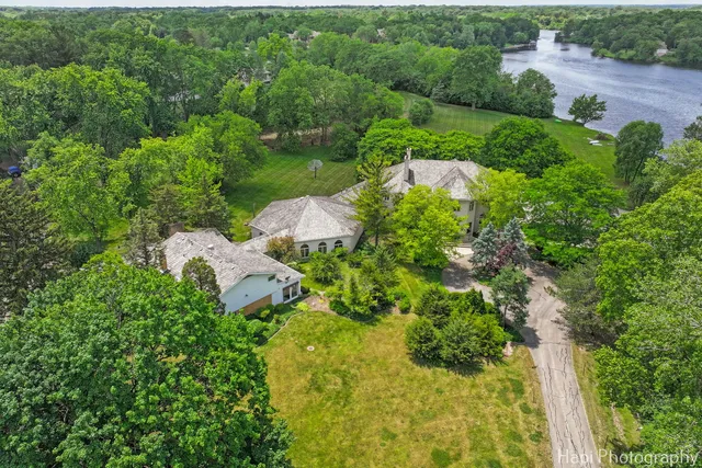 an aerial view of a house with a yard and outdoor seating
