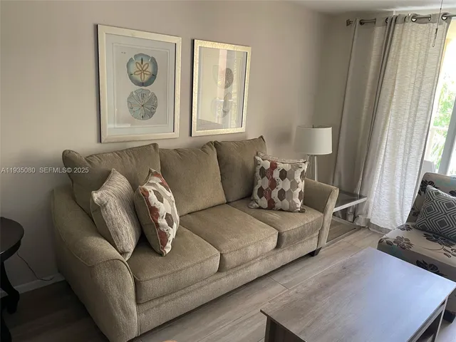 a living room with furniture and a floor to ceiling window