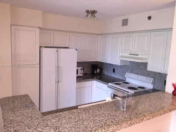 a kitchen with stainless steel appliances granite countertop a refrigerator sink and cabinets