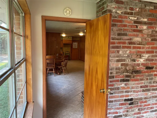 a view of a hallway with dining area and glass door
