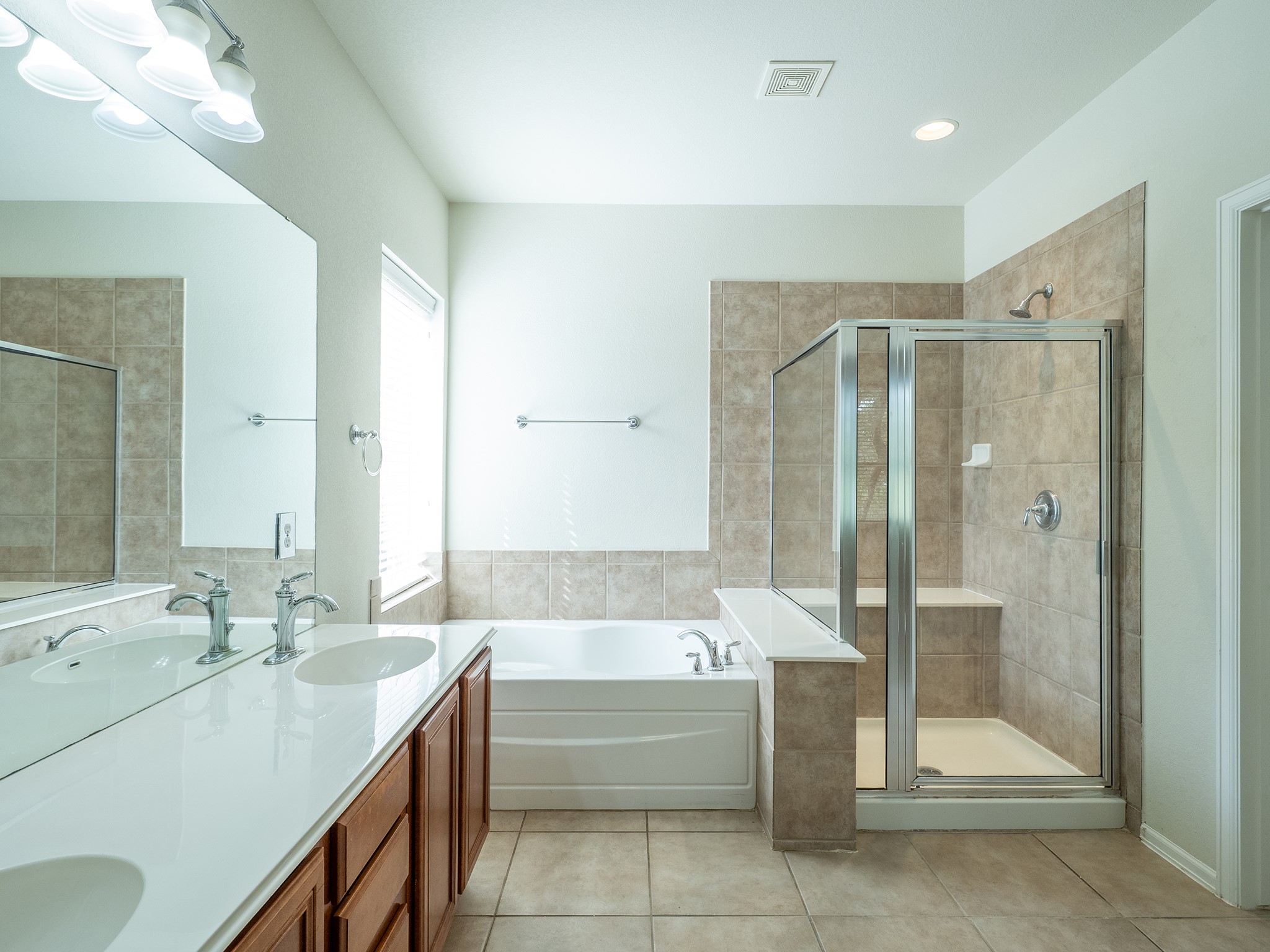 572 Big Meadow Road Austin, TX 78737 - Photo 17 of 32 Luxurious primary bath features a dual vanity, deep soaking tub, and a separate glass-enclosed shower.