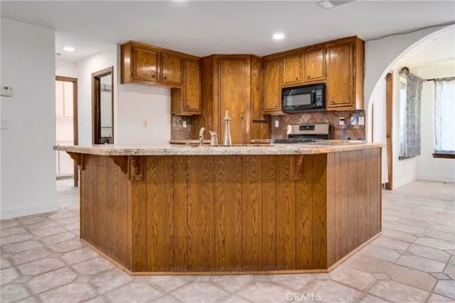 a kitchen with stainless steel appliances a refrigerator and a stove top oven