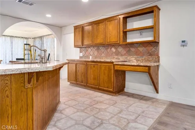 a kitchen with stainless steel appliances granite countertop a sink stove and cabinets