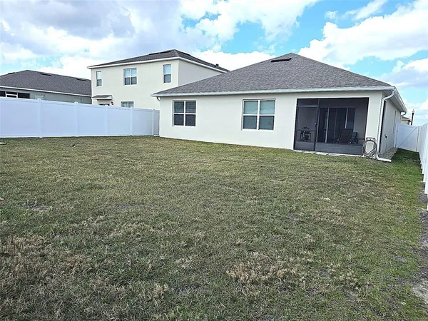 a view of a house with a backyard and a patio