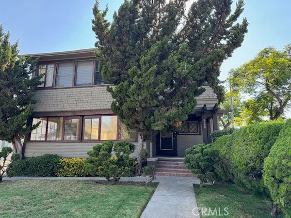 a front view of a house with a garden