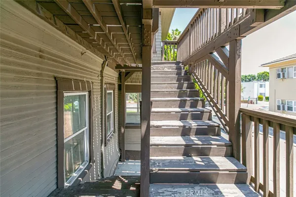 an empty room with chandelier fan and windows