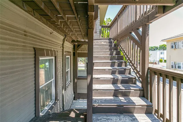 an empty room with chandelier fan and windows