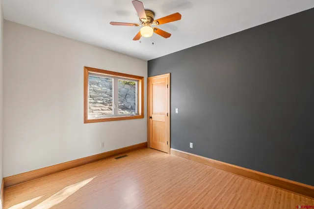 an empty room with windows and fan