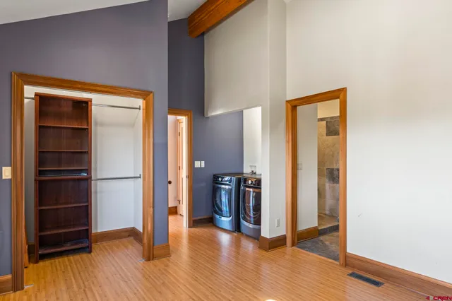 a view of a hallway with wooden floor and closet