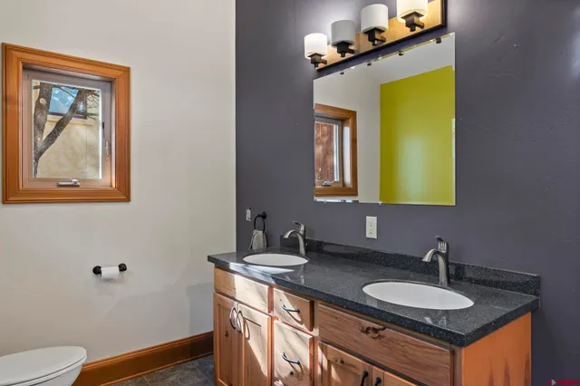 a bathroom with a granite countertop sink and a mirror