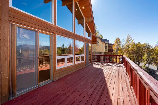 a view of a balcony with wooden floor and fence