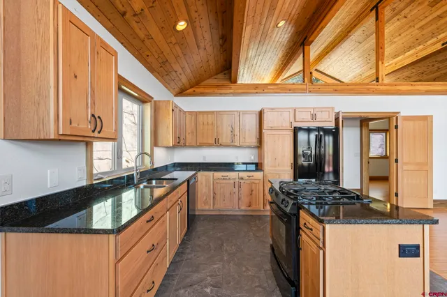 a kitchen with granite countertop a sink a counter top space and stainless steel appliances